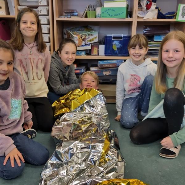 Kinder üben die Erste Hilfe